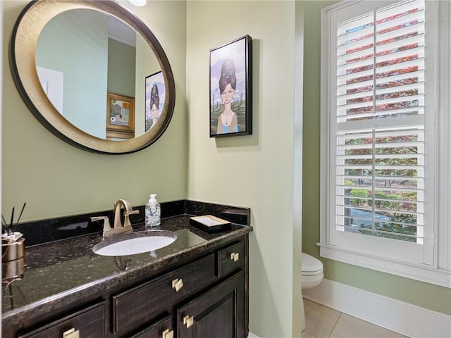 half bath featuring vanity, tile patterned floors, toilet, and baseboards