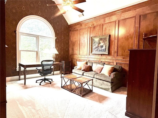 office area featuring visible vents, ceiling fan, lofted ceiling, carpet floors, and a decorative wall