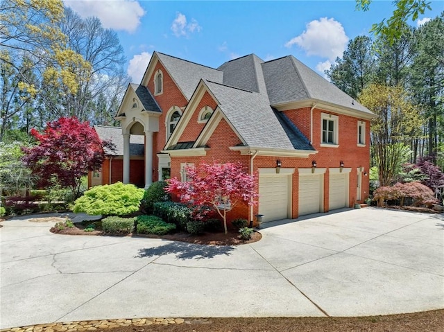 view of front facade with brick siding, driveway, and a shingled roof