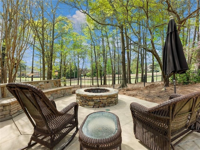 view of patio / terrace with a fire pit and fence