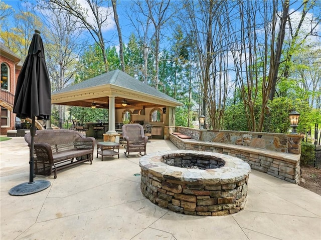 view of patio featuring a gazebo, ceiling fan, and an outdoor fire pit