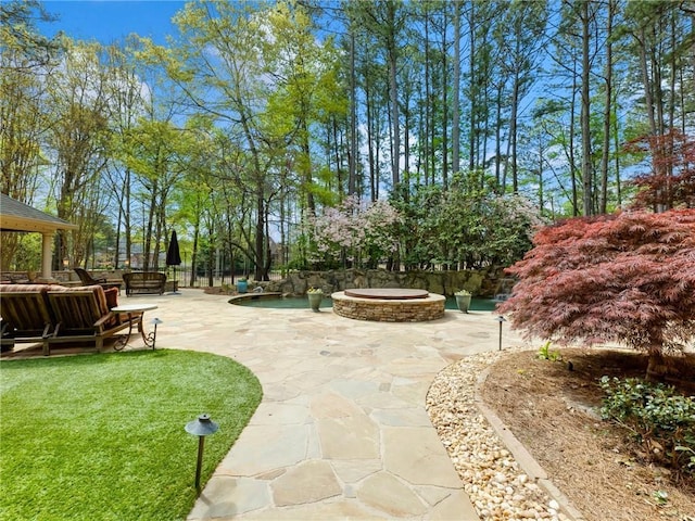 surrounding community featuring a yard, an outdoor living space with a fire pit, a patio, and fence