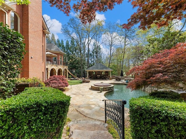 view of patio featuring an outbuilding and a fire pit