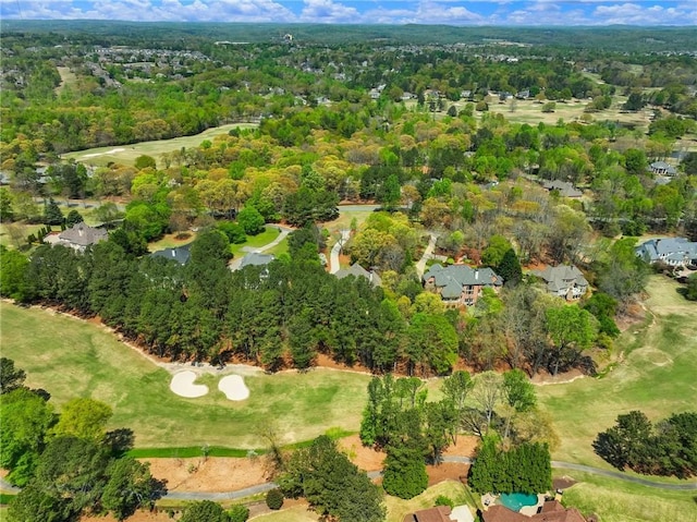 drone / aerial view with a forest view and view of golf course