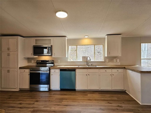 kitchen with stainless steel appliances, a sink, and white cabinetry