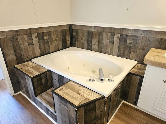 full bathroom with a whirlpool tub and wood finished floors