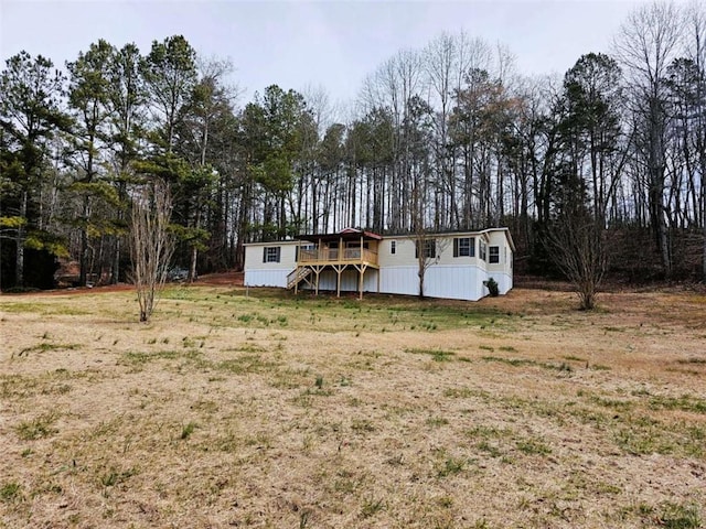 view of front of property featuring a front yard and a deck