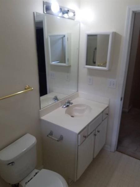 half bathroom featuring vanity and toilet