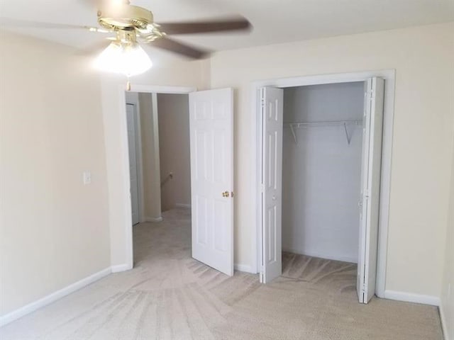 unfurnished bedroom featuring carpet floors, ceiling fan, baseboards, and a closet