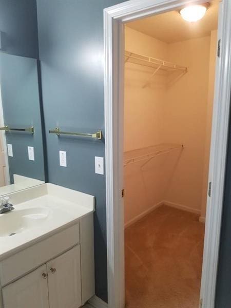 bathroom with vanity and a spacious closet