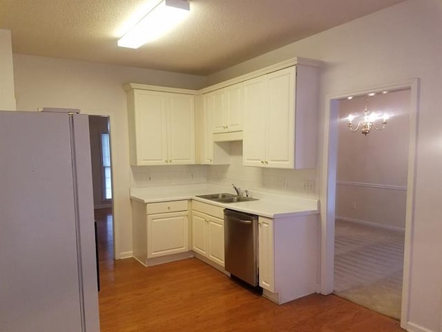 kitchen with light wood-type flooring, freestanding refrigerator, dishwasher, and light countertops