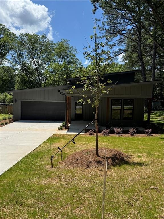 2588 Abner Pl NW, Atlanta, GA 30318 - mid-century modern home with board and batten siding, a garage, driveway, and a front lawn