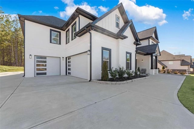 view of side of property featuring a garage, board and batten siding, and driveway