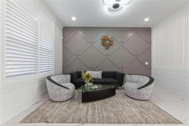 sitting room with an accent wall, a decorative wall, recessed lighting, and marble finish floor