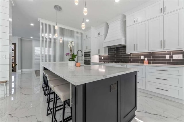 kitchen with white cabinetry, custom range hood, recessed lighting, and marble finish floor