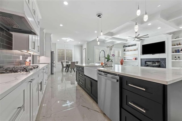 kitchen featuring marble finish floor, under cabinet range hood, recessed lighting, stainless steel appliances, and white cabinets