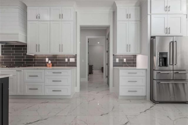 kitchen with marble finish floor, white cabinetry, high quality fridge, light countertops, and decorative backsplash