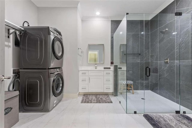 full bathroom with marble finish floor, ornamental molding, a stall shower, stacked washer / dryer, and vanity