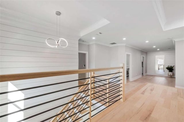 hallway with an upstairs landing, ornamental molding, recessed lighting, light wood-style floors, and baseboards