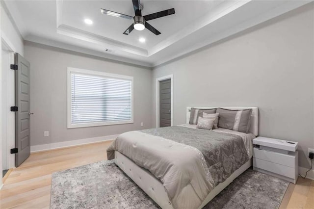 bedroom with a ceiling fan, baseboards, recessed lighting, light wood-style floors, and a raised ceiling