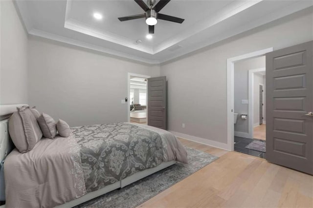 bedroom featuring a raised ceiling, recessed lighting, crown molding, light wood finished floors, and baseboards