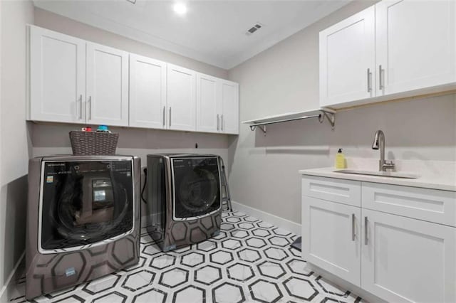 laundry area featuring visible vents, a sink, cabinet space, separate washer and dryer, and baseboards