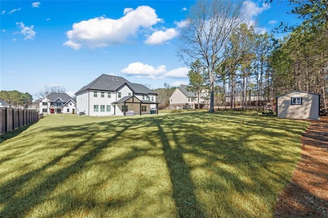 view of yard with an outbuilding, fence, and a shed