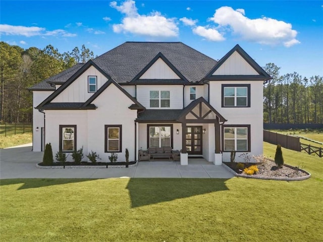 rear view of house featuring a lawn, fence, french doors, board and batten siding, and a shingled roof