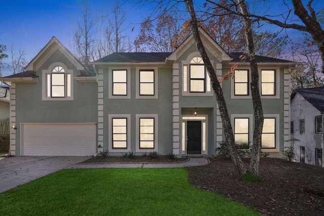 view of front of home with a garage and a lawn