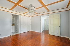 unfurnished bedroom featuring hardwood / wood-style floors, beam ceiling, and coffered ceiling