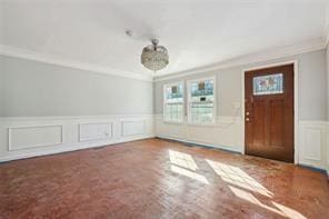 carpeted entrance foyer featuring ornamental molding