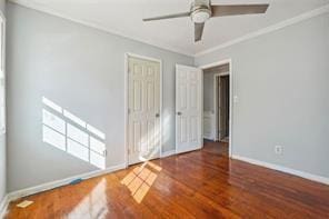 spare room with crown molding, wood-type flooring, and ceiling fan