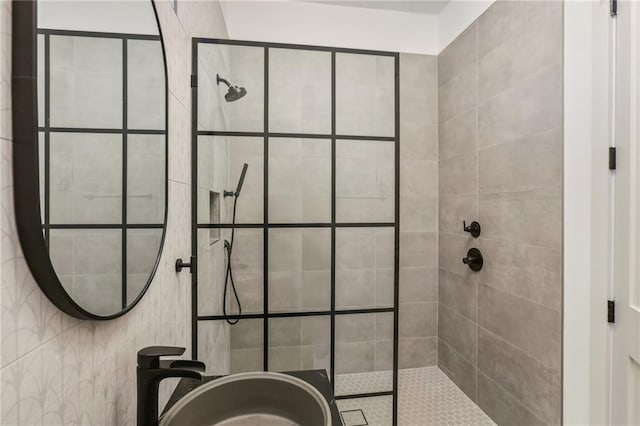 bathroom featuring a tile shower and sink