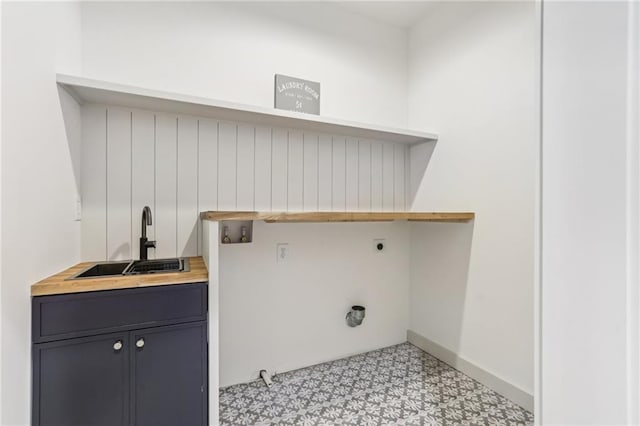 laundry area with electric dryer hookup, cabinets, and sink