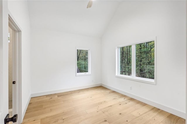 unfurnished room with light hardwood / wood-style floors and high vaulted ceiling