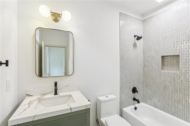 full bathroom featuring tiled shower / bath combo, toilet, and vanity