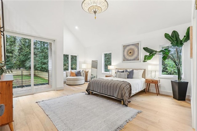 bedroom featuring access to outside, high vaulted ceiling, and light hardwood / wood-style floors