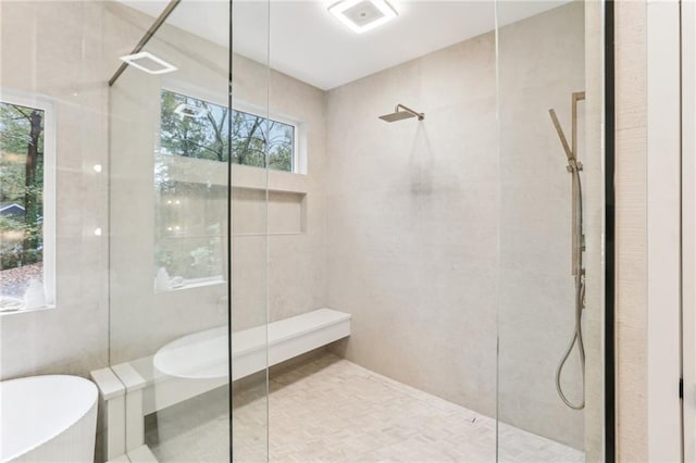 bathroom with tile walls and independent shower and bath