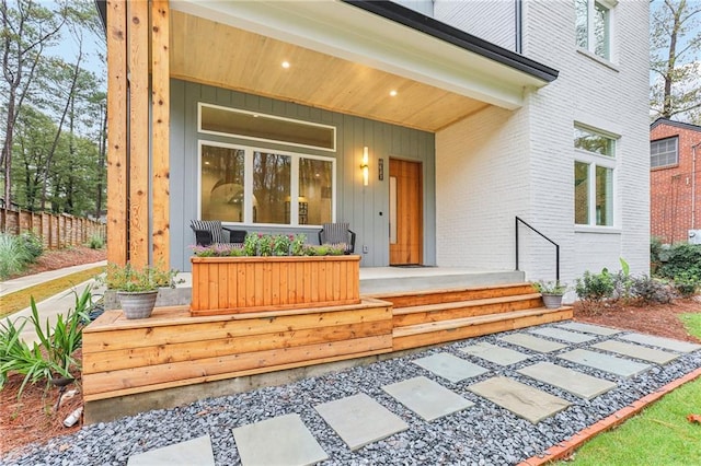 view of exterior entry featuring covered porch