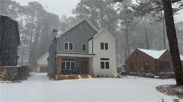 view of snow covered rear of property