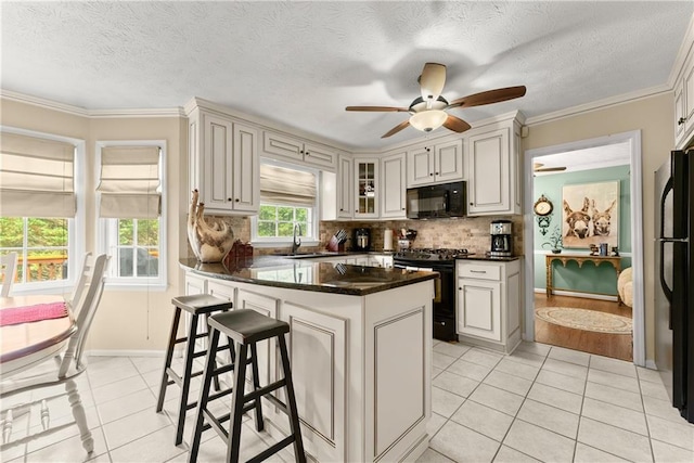 1083 Wash Lee Dr SW, Lilburn, GA 30047 - kitchen with black appliances, light tile patterned floors, backsplash, a ceiling fan, and a breakfast bar area
