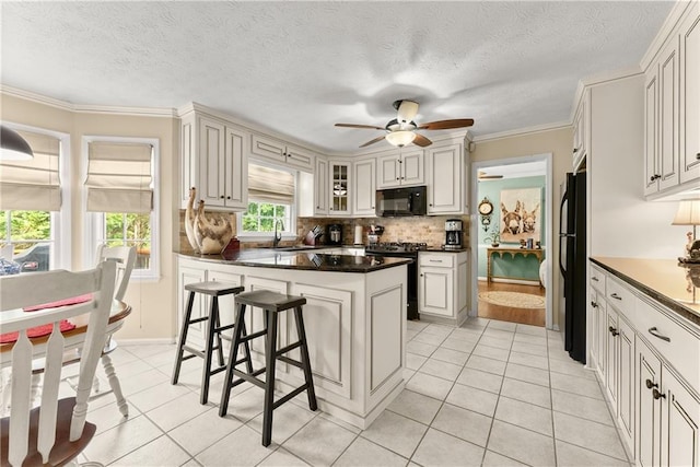 1083 Wash Lee Dr SW, Lilburn, GA 30047 - kitchen with black appliances, light tile patterned floors, decorative backsplash, dark countertops, and a textured ceiling