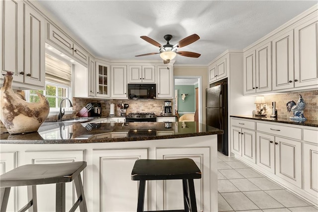 1083 Wash Lee Dr SW, Lilburn, GA 30047 - kitchen featuring black appliances, backsplash, ceiling fan, light tile patterned flooring, and dark stone counters