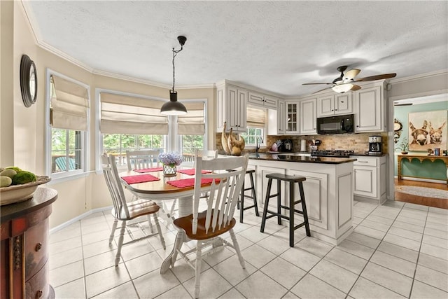 1083 Wash Lee Dr SW, Lilburn, GA 30047 - dining room featuring light tile patterned flooring, ornamental molding, ceiling fan, and a textured ceiling