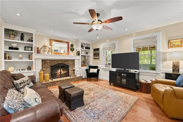 1083 Wash Lee Dr SW, Lilburn, GA 30047 - living room with crown molding, wood finished floors, a brick fireplace, a ceiling fan, and built in shelves