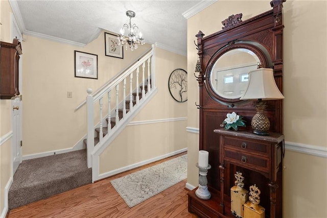 1083 Wash Lee Dr SW, Lilburn, GA 30047 - staircase featuring wood finished floors, a chandelier, crown molding, and a textured ceiling