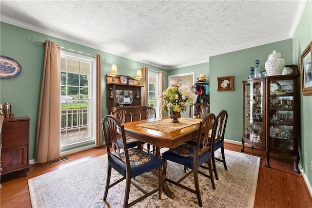 1083 Wash Lee Dr SW, Lilburn, GA 30047 - dining area with crown molding, wood finished floors, and a textured ceiling