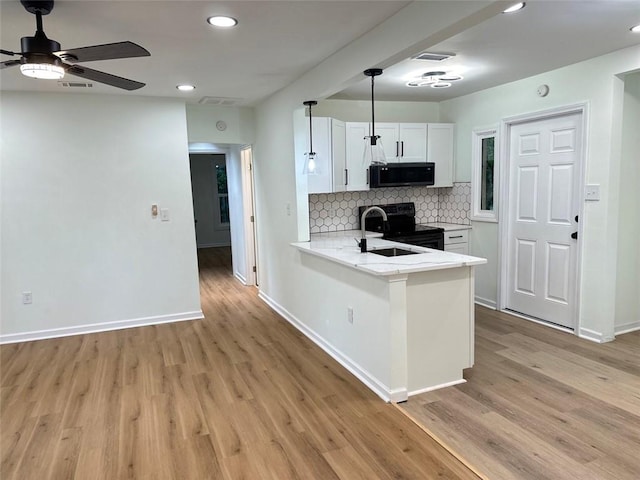 kitchen with light hardwood / wood-style flooring, range with electric cooktop, hanging light fixtures, white cabinetry, and ceiling fan