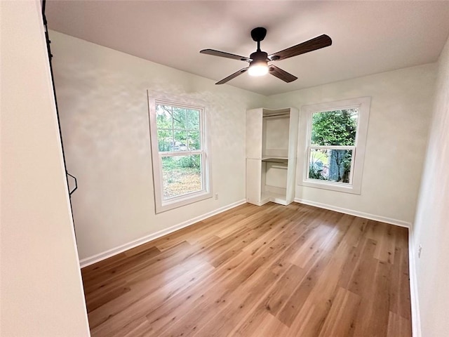 unfurnished bedroom with multiple windows, ceiling fan, and light hardwood / wood-style floors