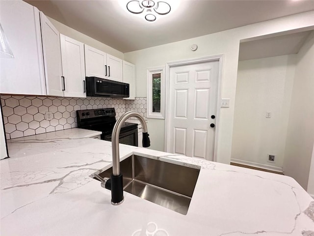 kitchen with white cabinetry, stainless steel electric range, backsplash, and light stone counters